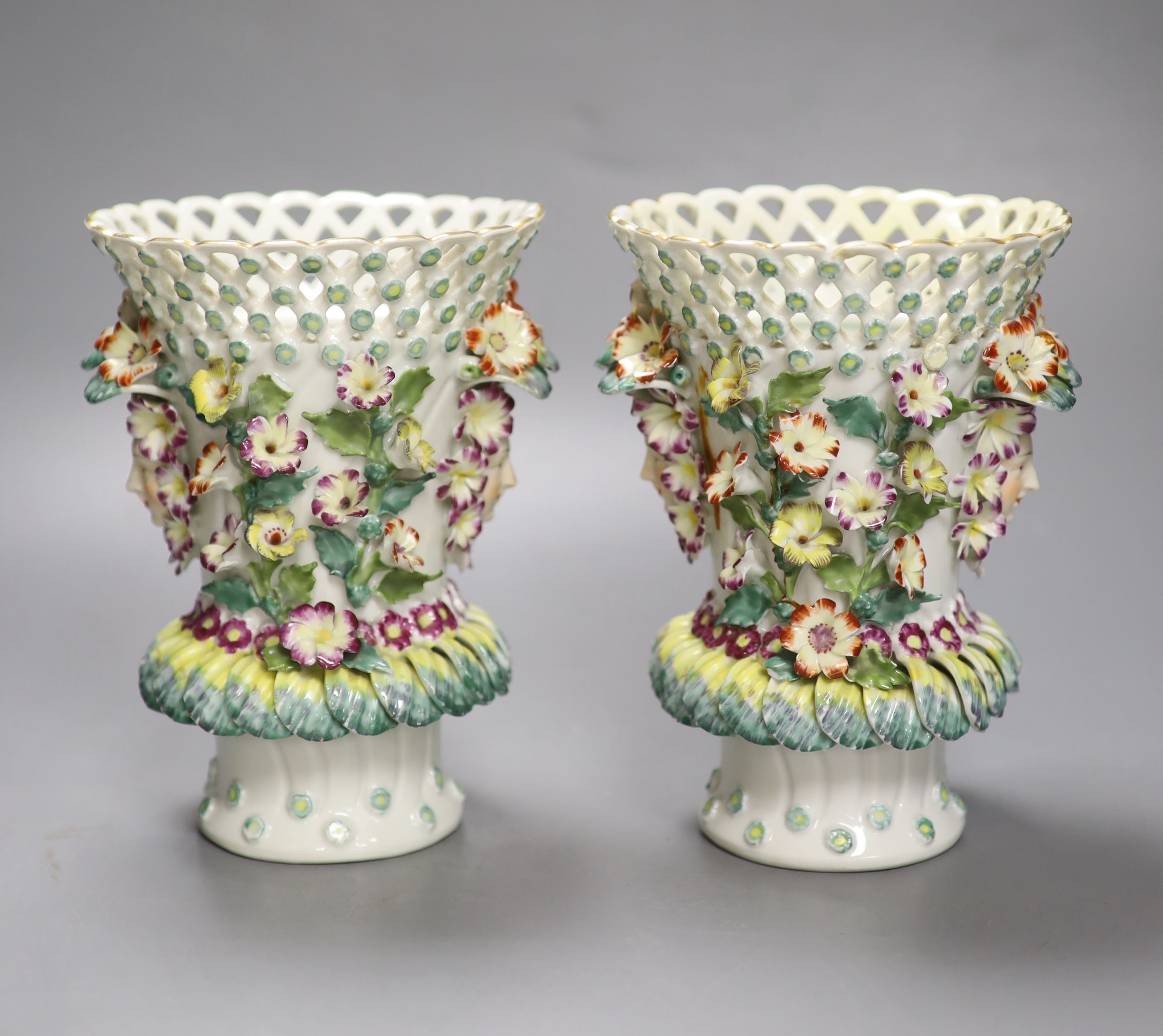 A pair of Continental frill vases with pierced necks and applied mask heads encrusted with flowers, height 18cm